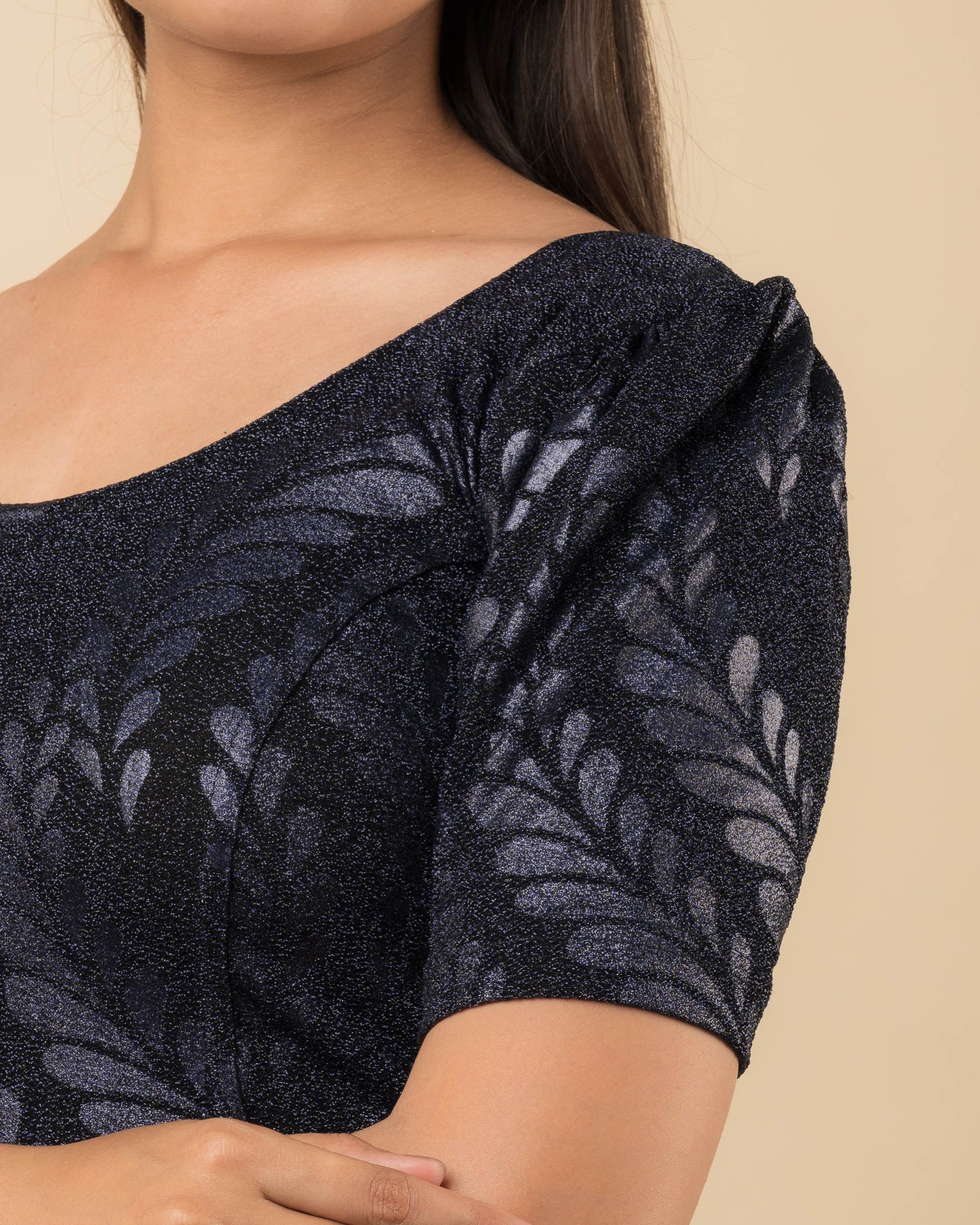 Close-up of bright gold metallic zari stretchable lycra blouse with detailed emboss texture.