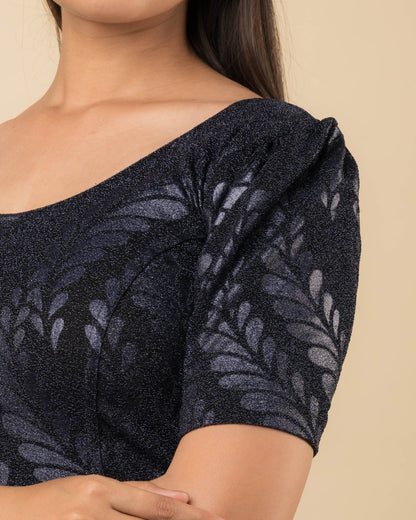 Close-up of bright gold metallic zari stretchable lycra blouse with detailed emboss texture.