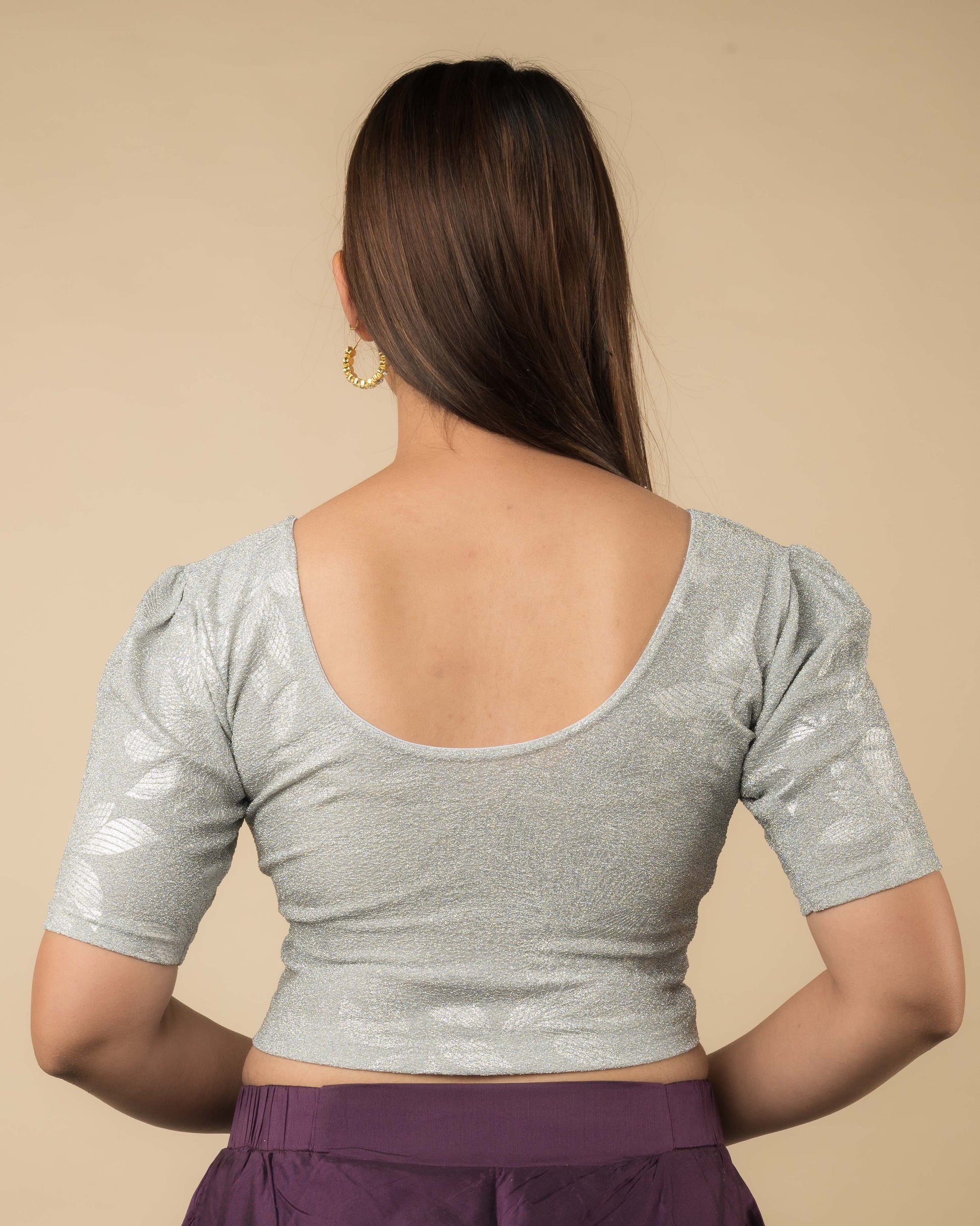 Rear view of the metallic blouse highlighting embossed design and flattering fit.