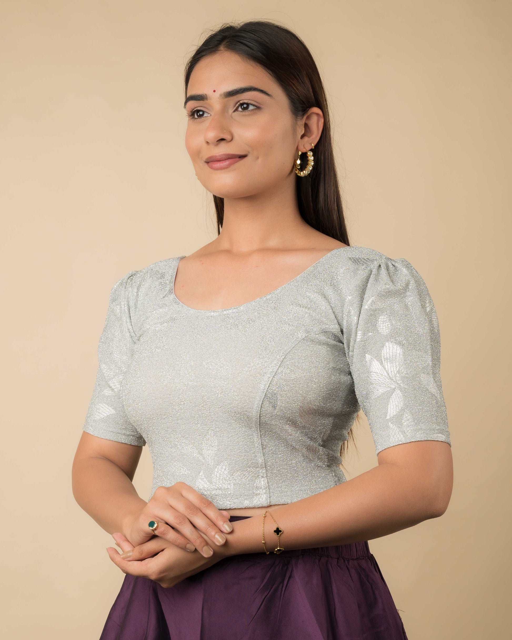 Side angle showcasing the puff sleeves, tailored shape, and textured shimmer.
