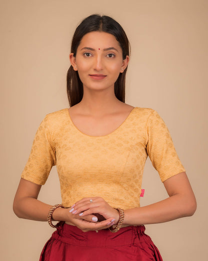 Model wearing a stretchable blouse with elbow sleeves and round neckline featuring foil floral detailing.