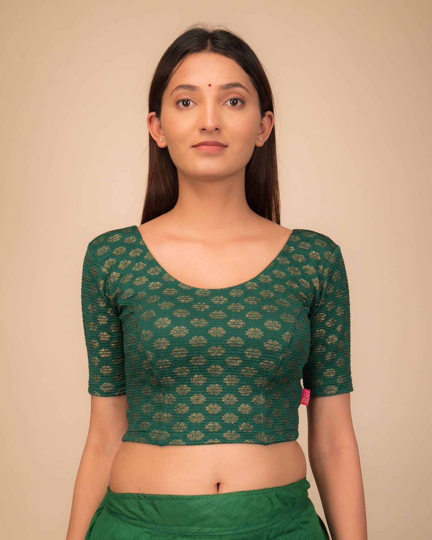 Model wearing a stretchable blouse with elbow sleeves and round neckline featuring foil floral detailing.