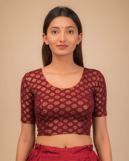 Model wearing a stretchable blouse with elbow sleeves and round neckline featuring foil floral detailing.