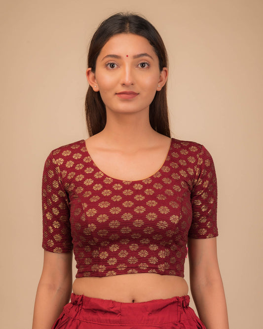 Model wearing a stretchable blouse with elbow sleeves and round neckline featuring foil floral detailing.