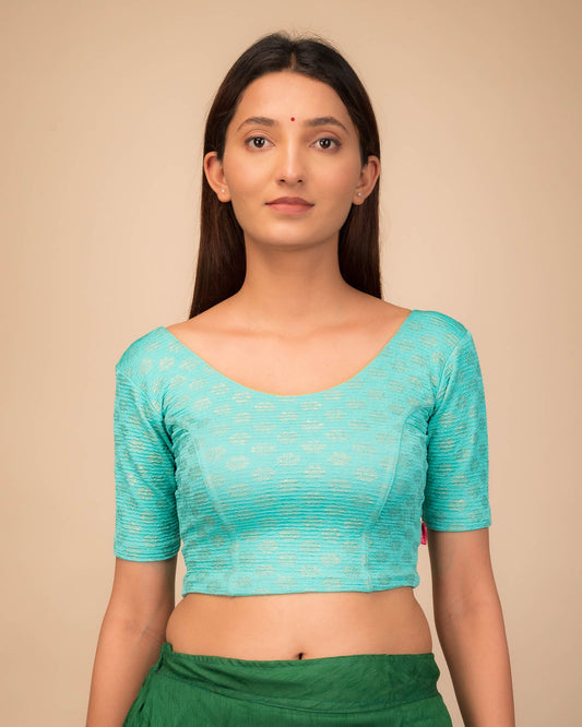 Model wearing a stretchable blouse with elbow sleeves and round neckline featuring foil floral detailing.