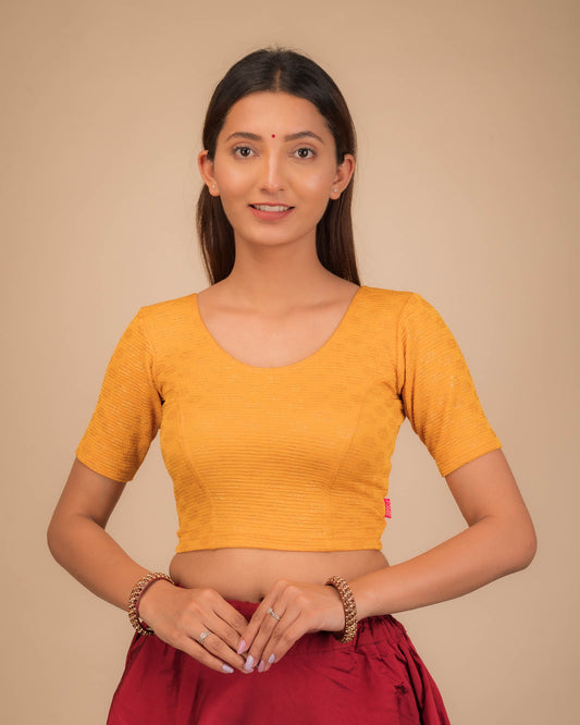 Model wearing a stretchable blouse with elbow sleeves and round neckline featuring foil floral detailing.