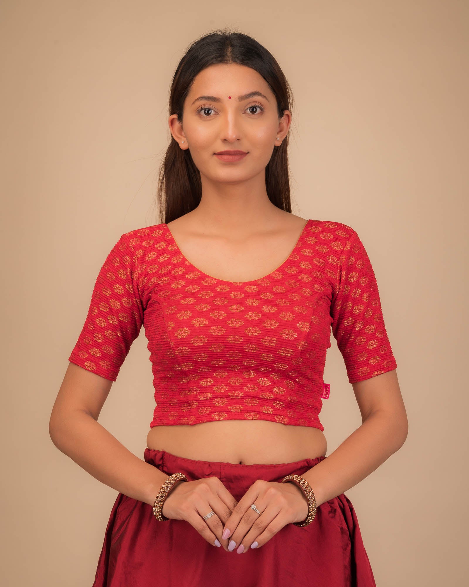 Model wearing a stretchable blouse with elbow sleeves and round neckline featuring foil floral detailing.