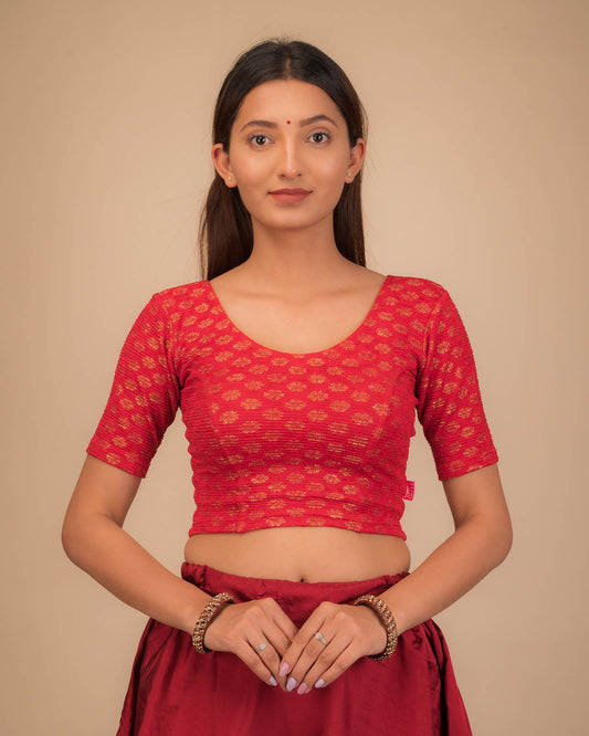 Model wearing a stretchable blouse with elbow sleeves and round neckline featuring foil floral detailing.