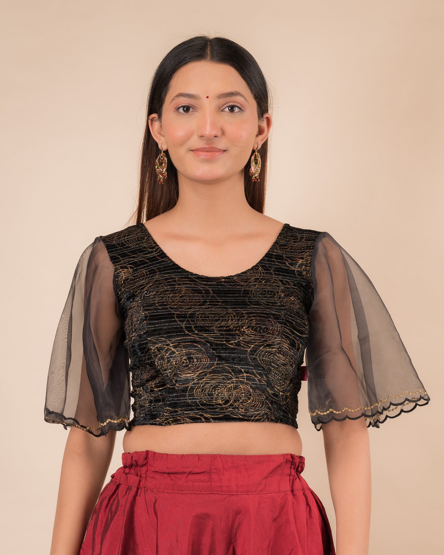 Model wearing a velvet slip-on blouse with elbow bell sleeves and round neckline.