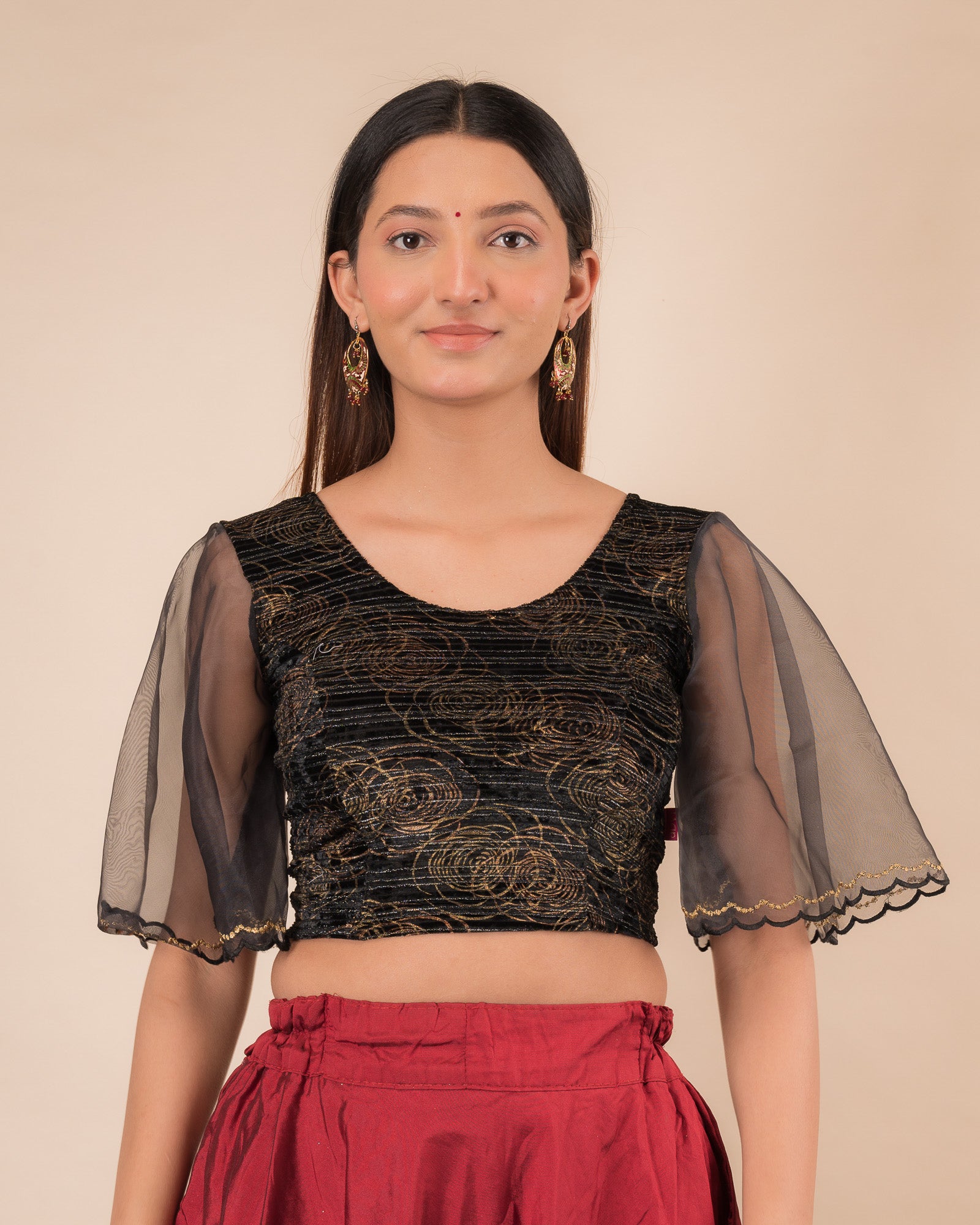 Model wearing a velvet slip-on blouse with elbow bell sleeves and round neckline.
