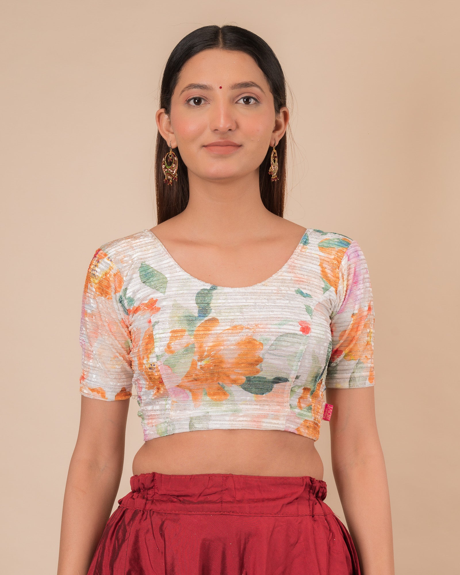  Model wearing a stretchable velvet blouse with elbow sleeves and round neckline, showcasing a floral print.