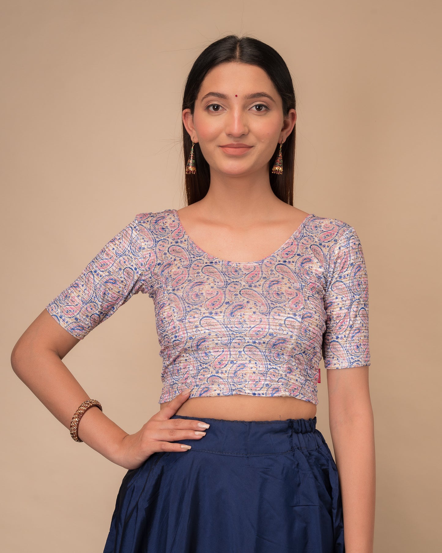 Model wearing a stretchable velvet blouse with elbow sleeves and round neckline, showcasing a floral print.
