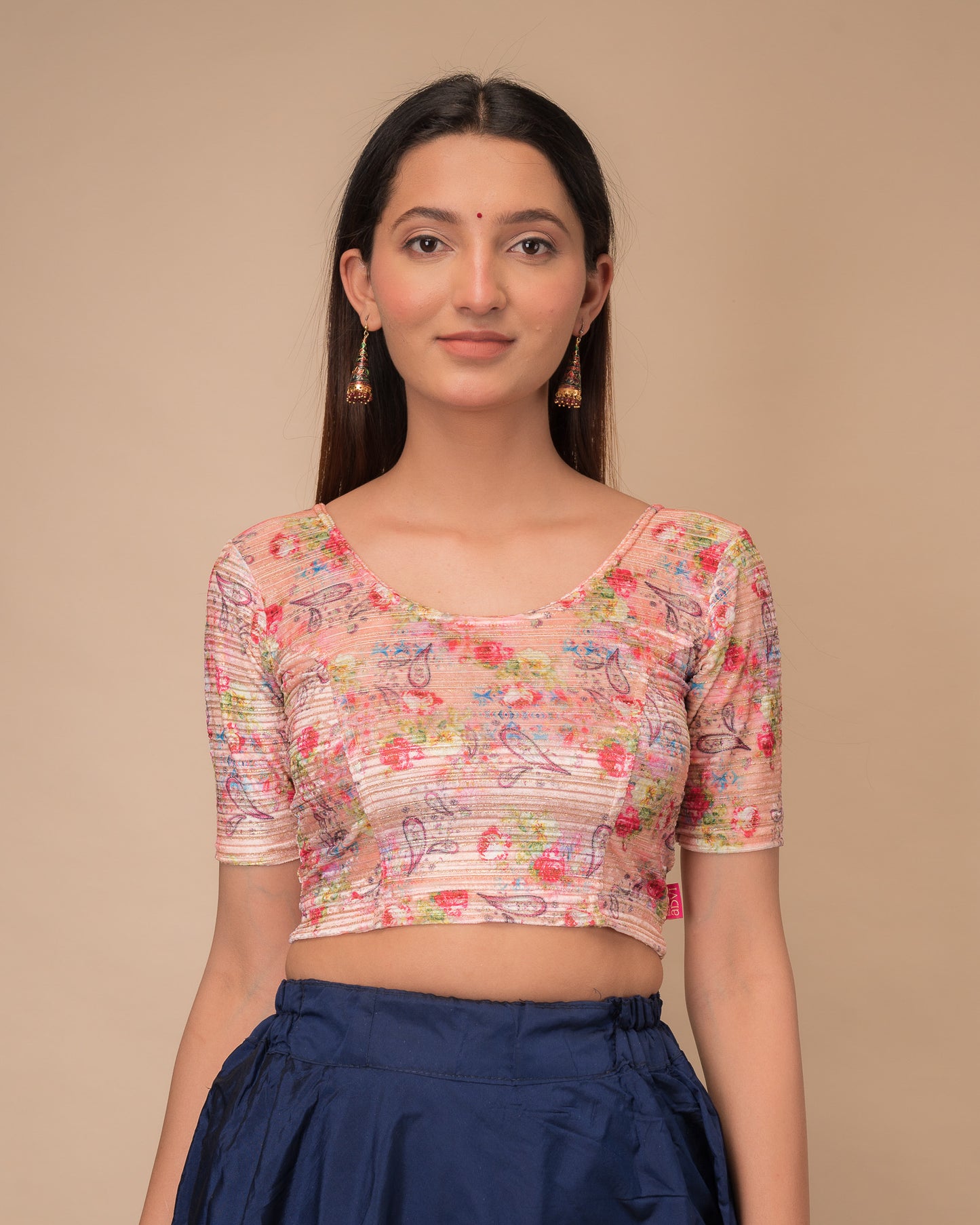 Model wearing a stretchable velvet blouse with elbow sleeves and round neckline, showcasing a floral print.