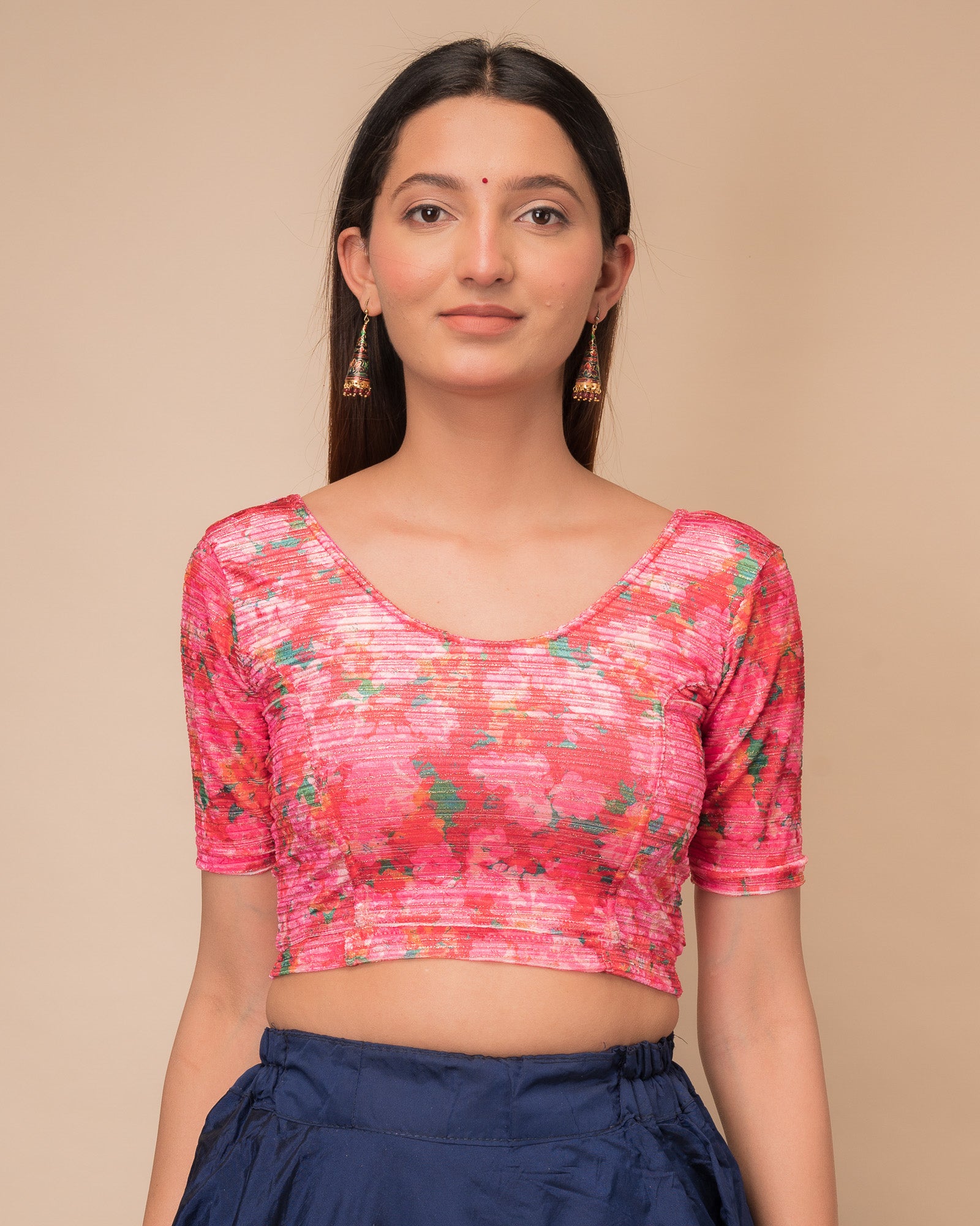 Model wearing a stretchable velvet blouse with elbow sleeves and round neckline, showcasing a floral print.