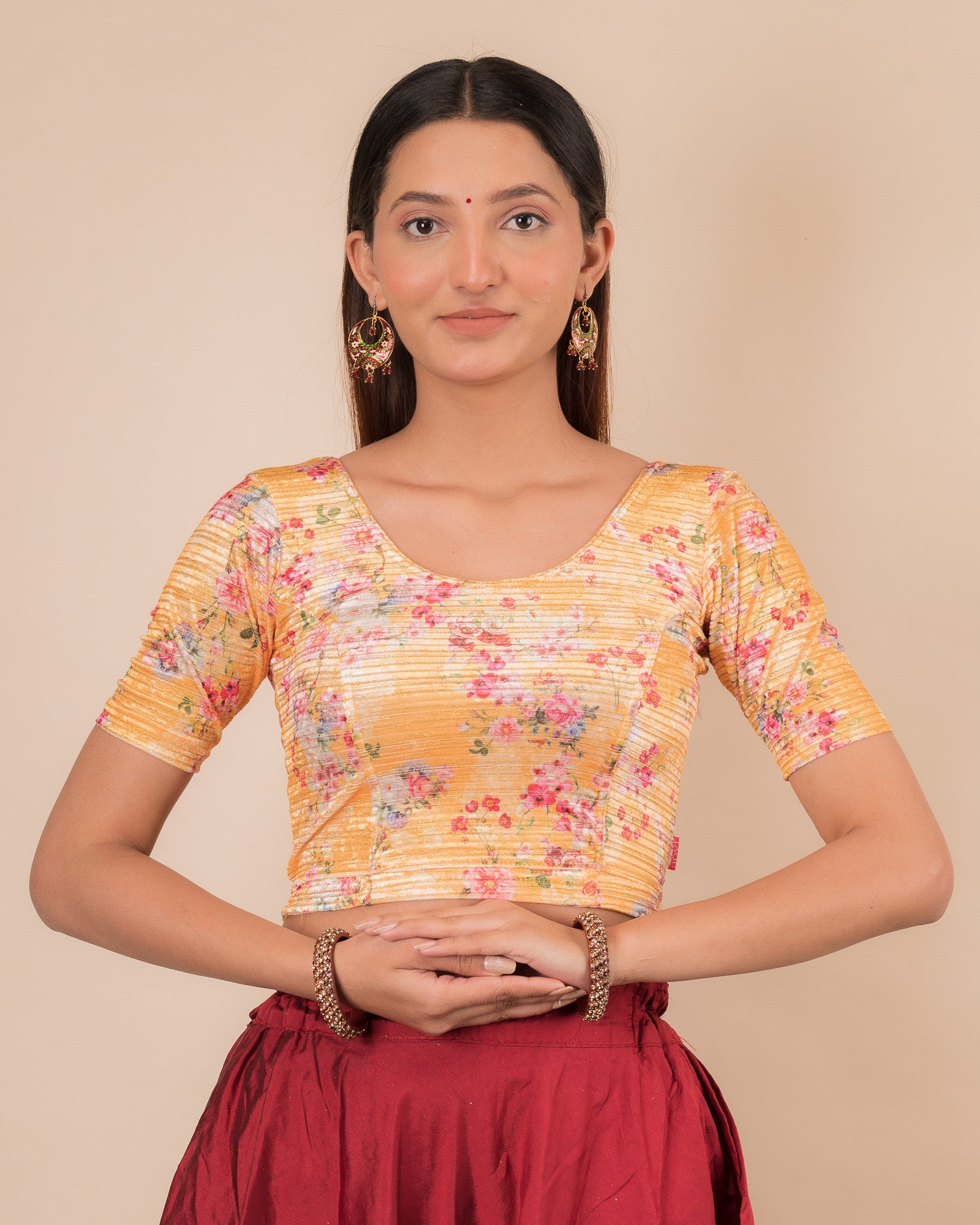 Model wearing a stretchable velvet blouse with elbow sleeves and round neckline, showcasing a floral print.
