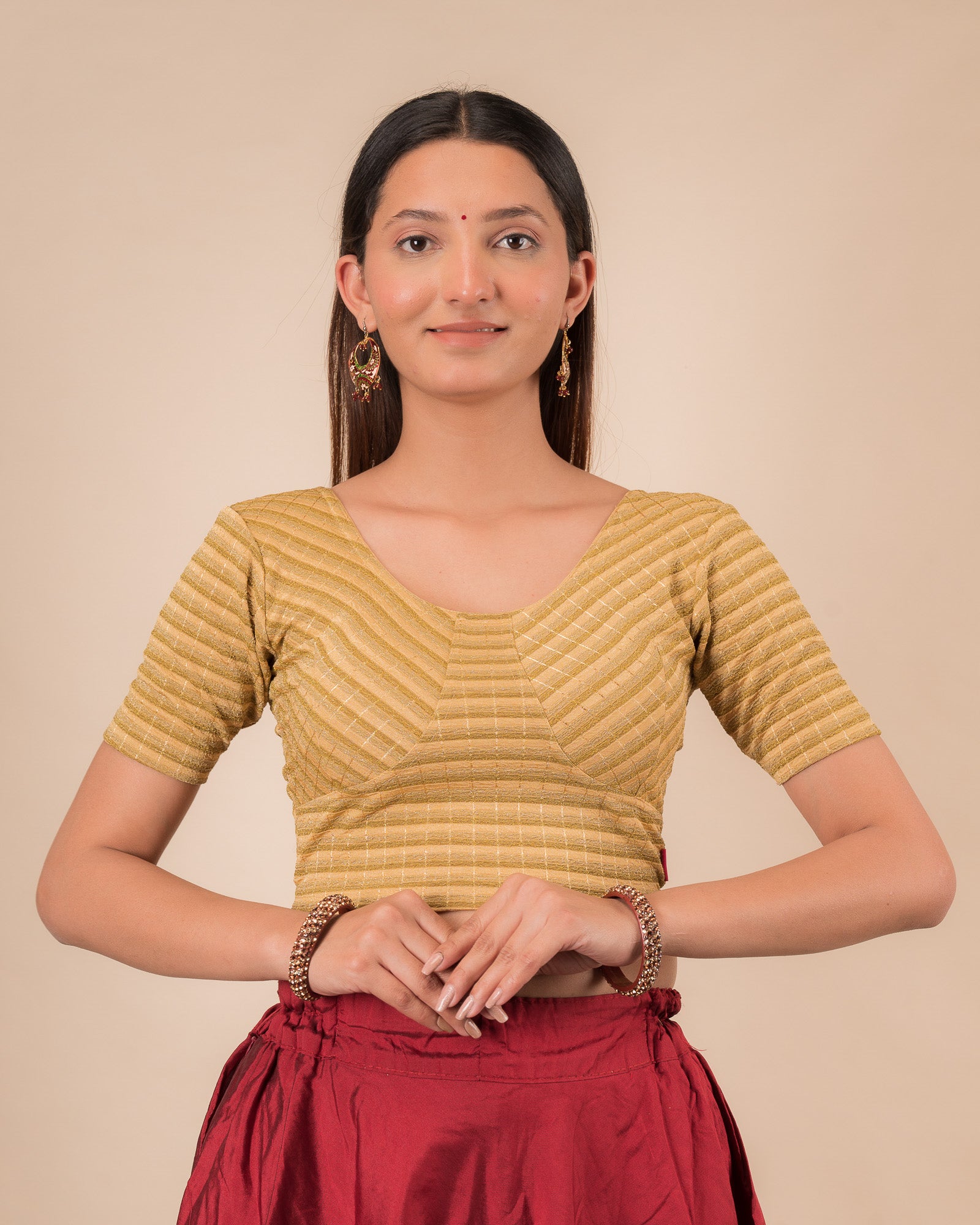 Model wearing a gold  zari stripe stretchable readymade blouse with elbow sleeves and round neckline