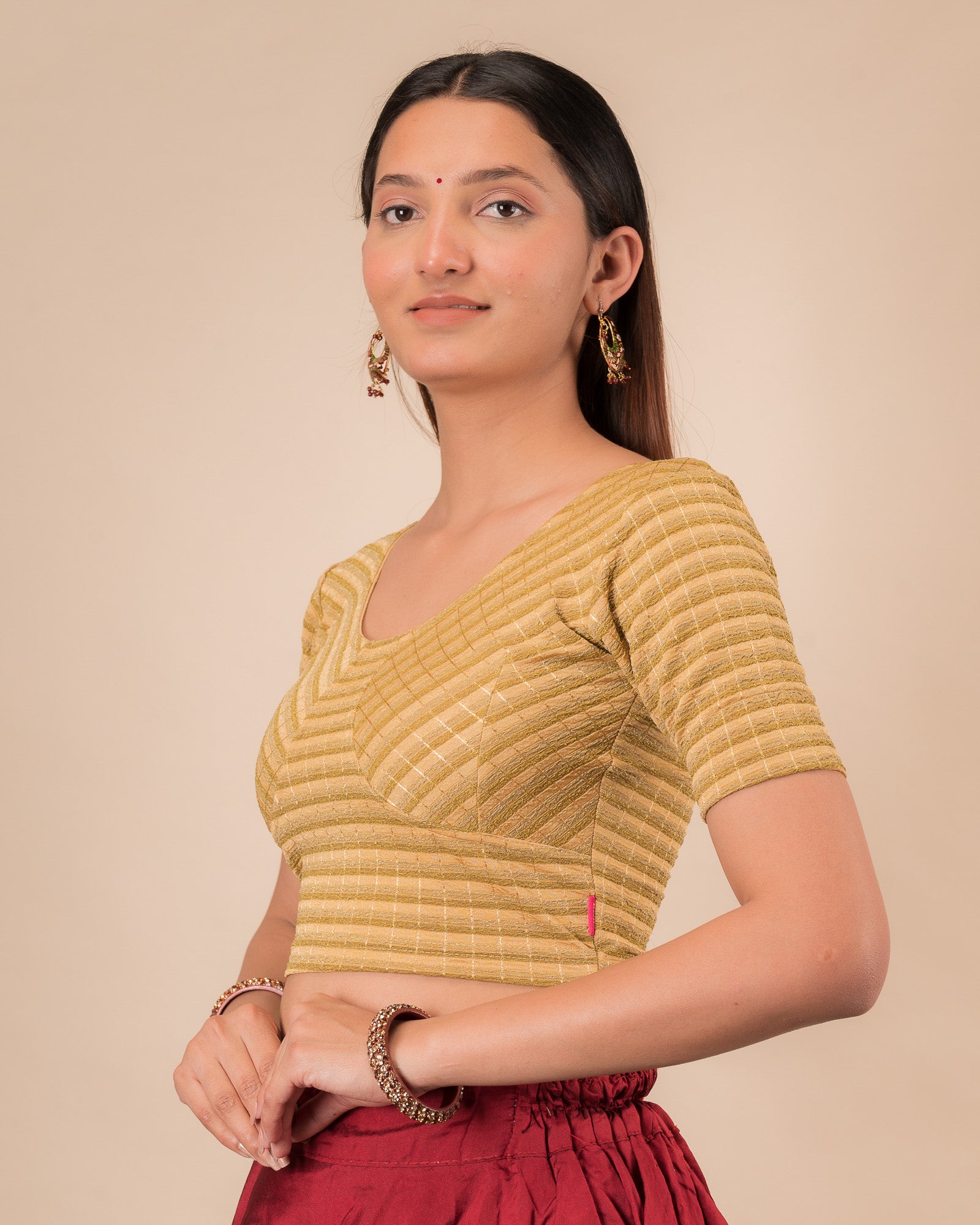 Side profile of the gold  zari stripe stretchable blouse highlighting the fit and sleeve length