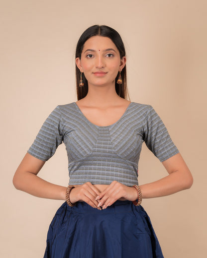Model wearing a zari stripe stretchable readymade blouse with elbow sleeves and round neckline