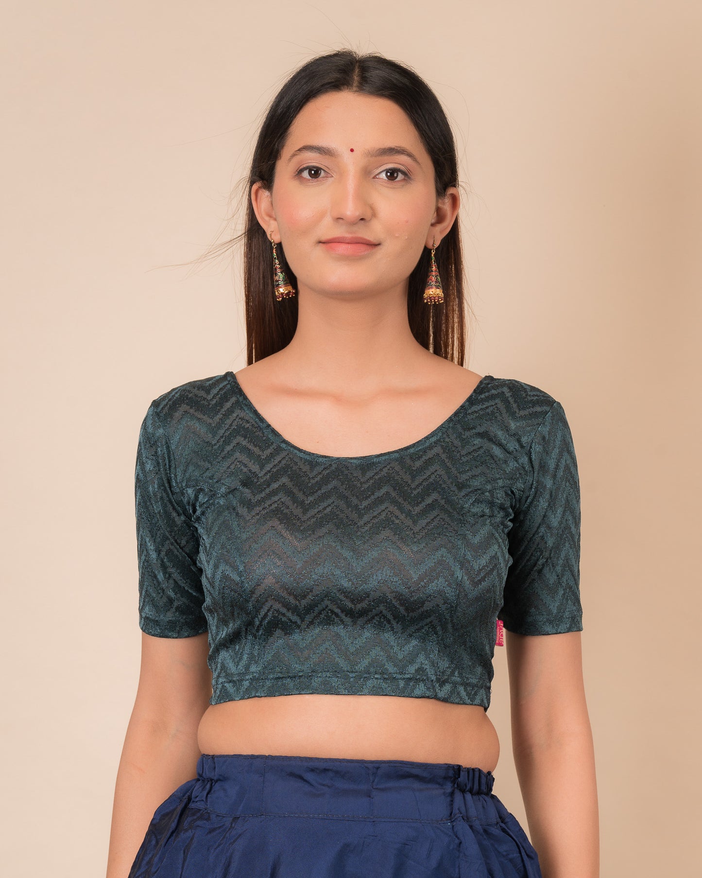 Model wearing a maroon melange zig-zag patterned stretchable readymade blouse with elbow sleeves and round neckline.