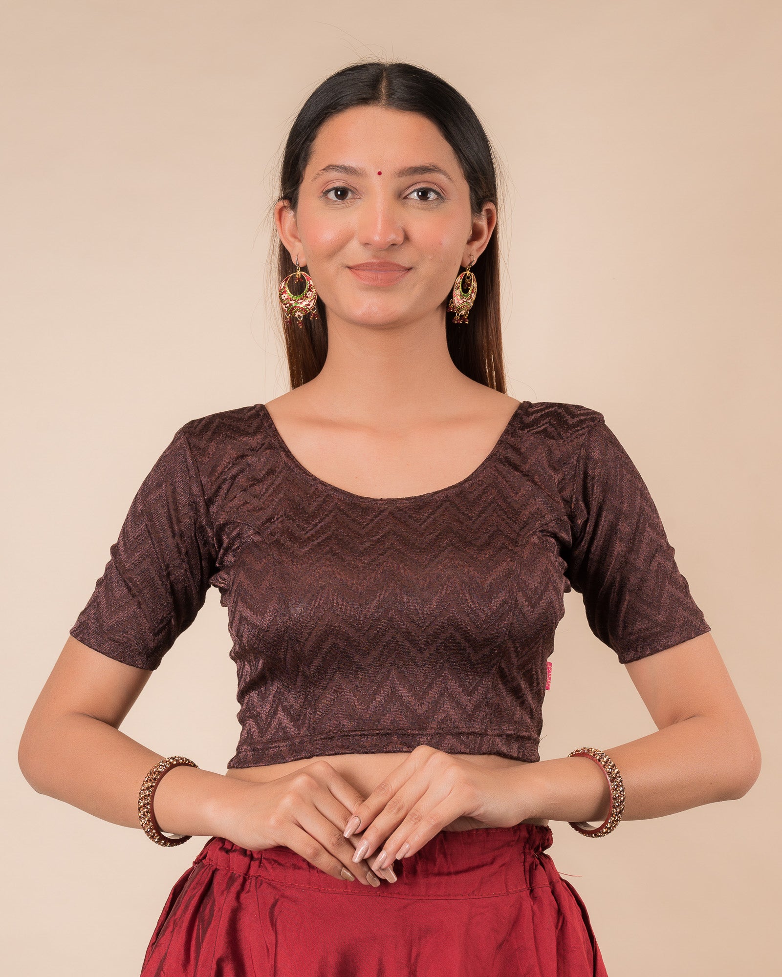 Model wearing a maroon melange zig-zag patterned stretchable readymade blouse with elbow sleeves and round neckline