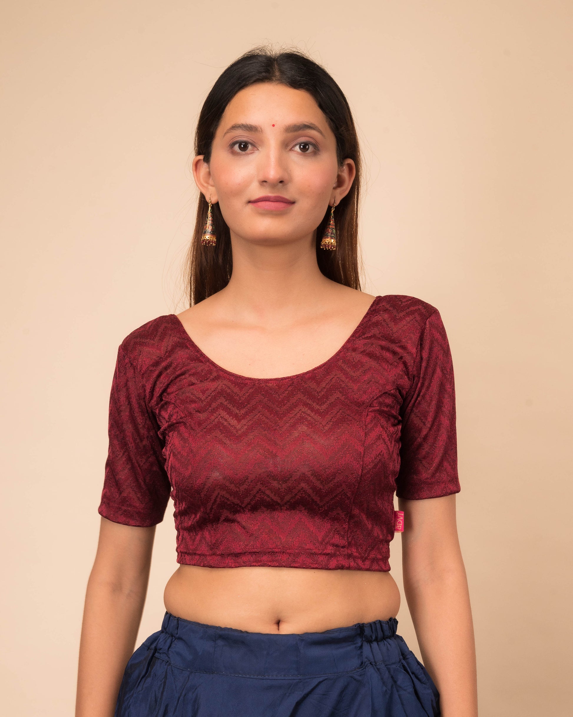 Model wearing a maroon melange zig-zag patterned stretchable readymade blouse with elbow sleeves and round neckline