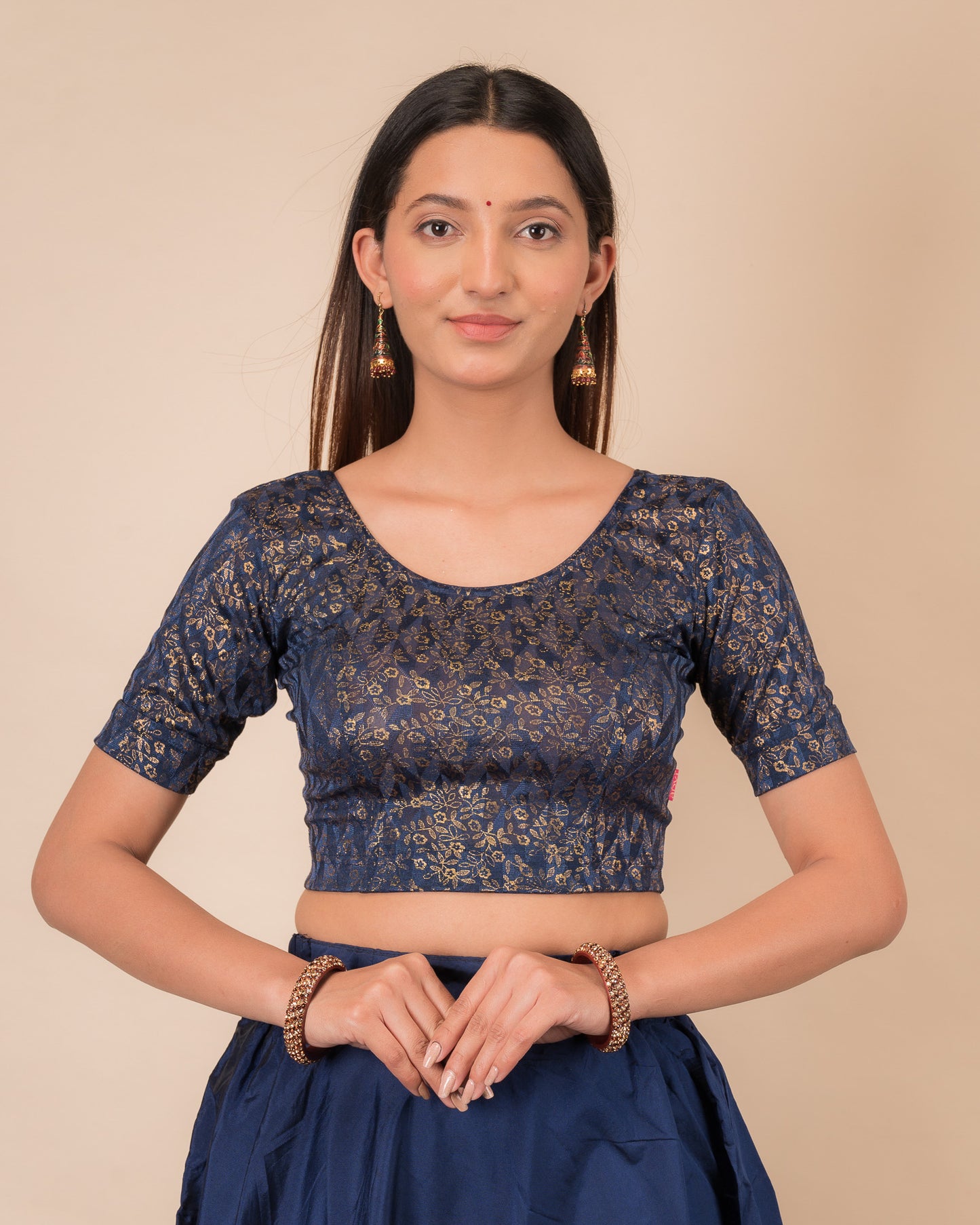 Model wearing a floral foil stretchable blouse with elbow sleeves, round neckline, and ruffle detail