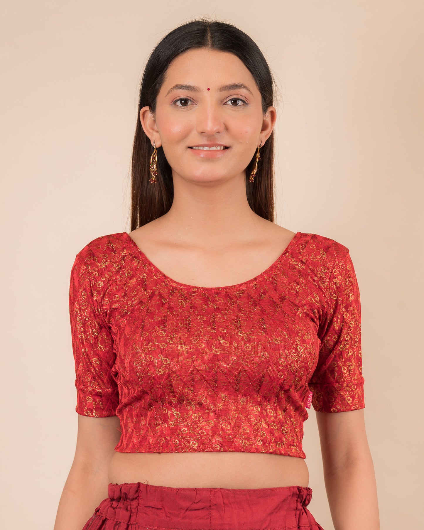 Model wearing a floral foil stretchable blouse with elbow sleeves, round neckline, and ruffle detail