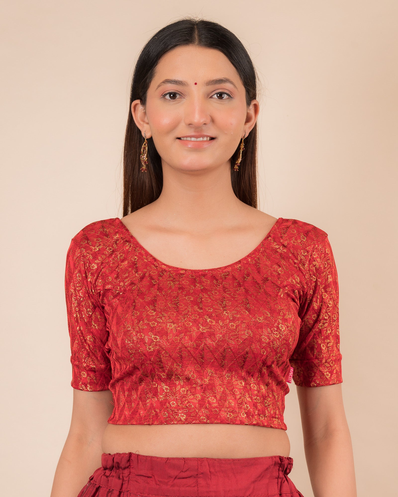 Model wearing a floral foil stretchable blouse with elbow sleeves, round neckline, and ruffle detail