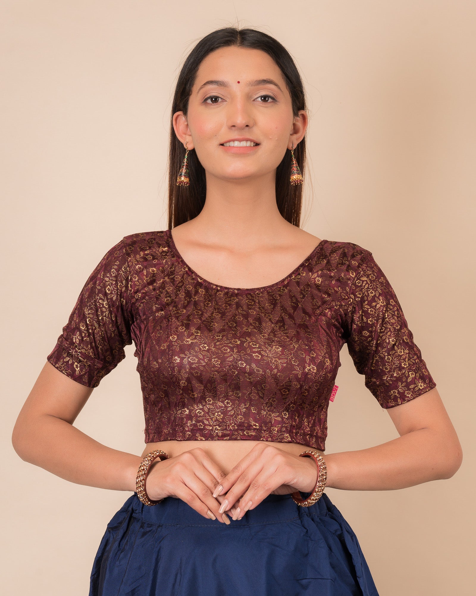  Model wearing a floral foil stretchable blouse with elbow sleeves, round neckline, and ruffle detail