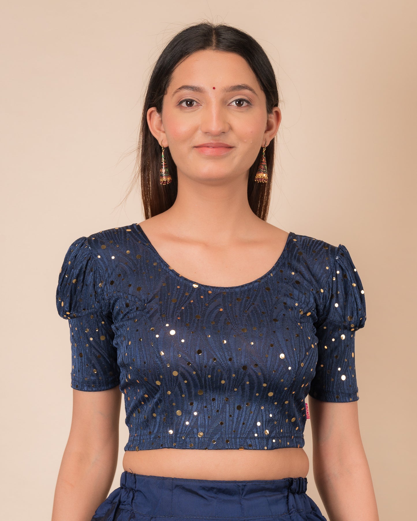 Model wearing a red stretchable blouse with gold mirror embellishments, puff sleeves, and round neckline