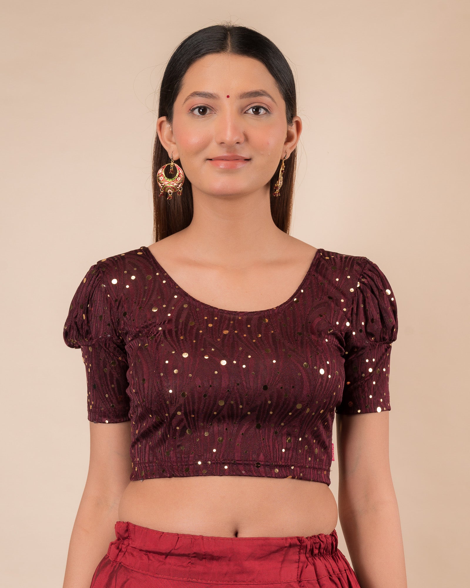 Model wearing a red stretchable blouse with gold mirror embellishments, puff sleeves, and round neckline