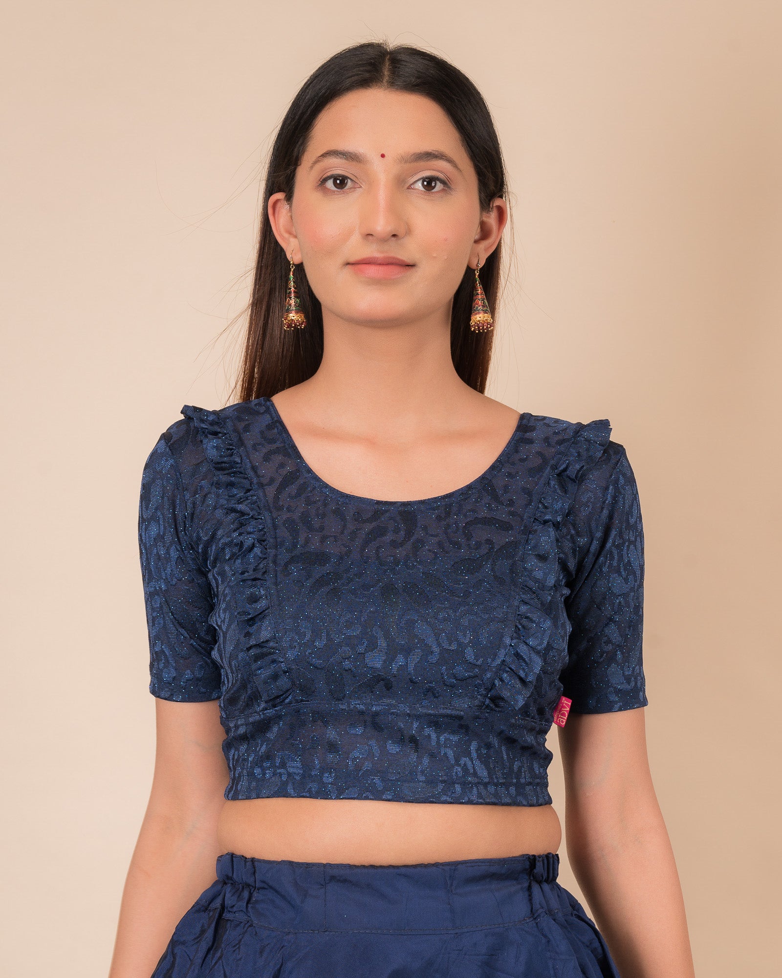 Model wearing an orange paisley paisley stretchable blouse with glitter, ruffled shoulders, elbow sleeves, and round neckline