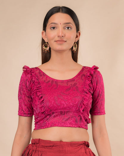 Model wearing an orange paisley paisley stretchable blouse with glitter, ruffled shoulders, elbow sleeves, and round neckline