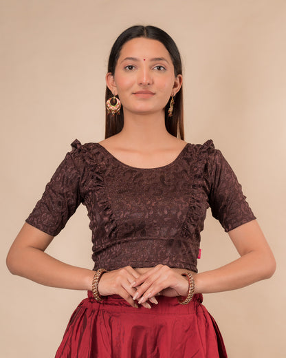 Model wearing an orange paisley paisley stretchable blouse with glitter, ruffled shoulders, elbow sleeves, and round neckline