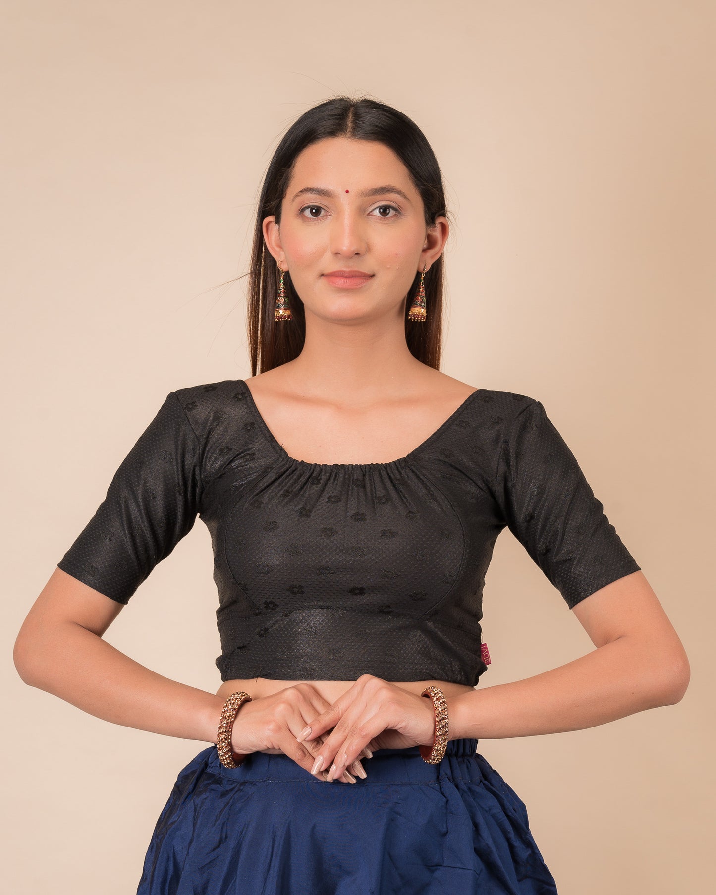Model wearing a metallic zig-zag striped stretchable choli-style blouse with elbow sleeves and round neckline