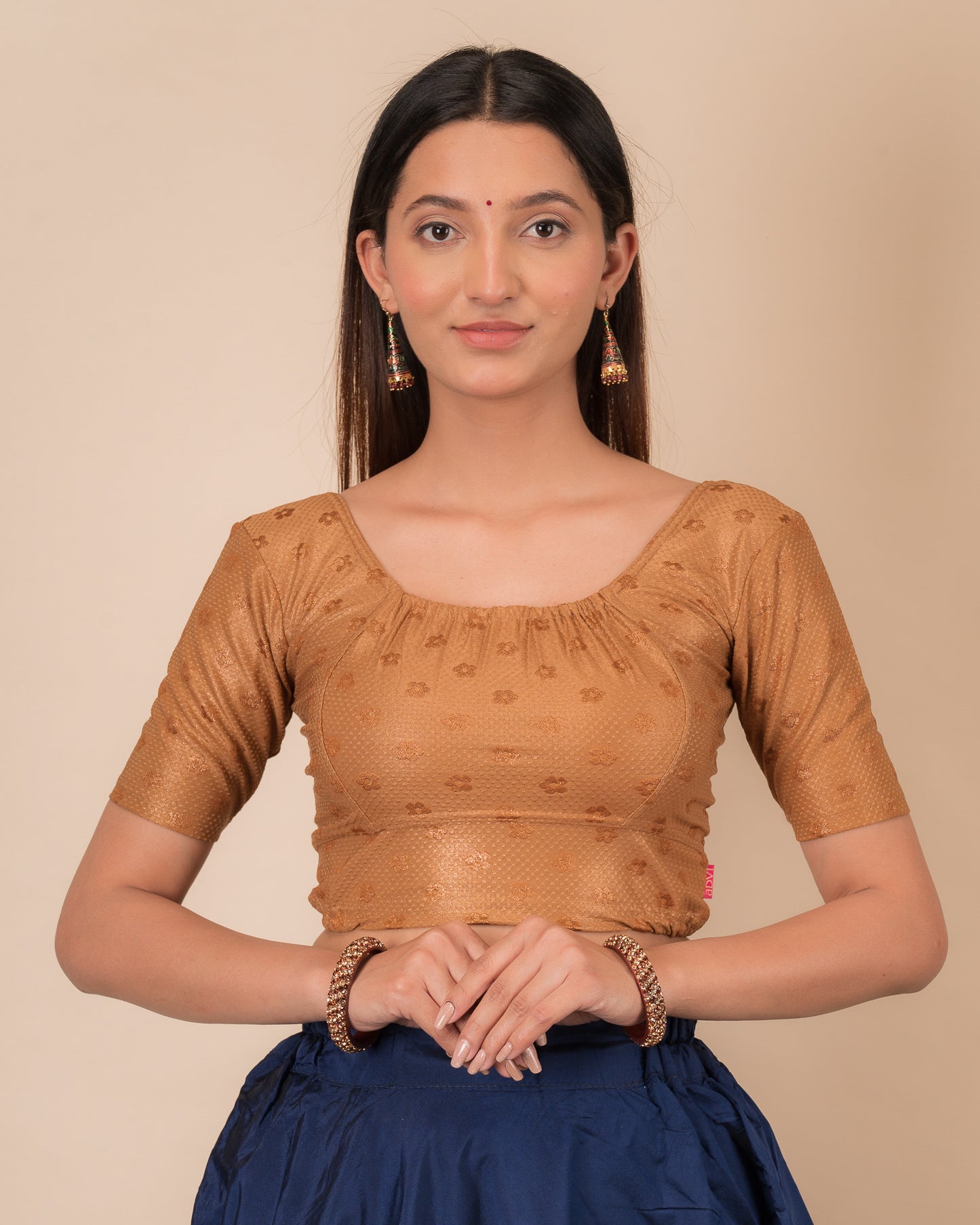 Model wearing a metallic zig-zag striped stretchable choli-style blouse with elbow sleeves and round neckline