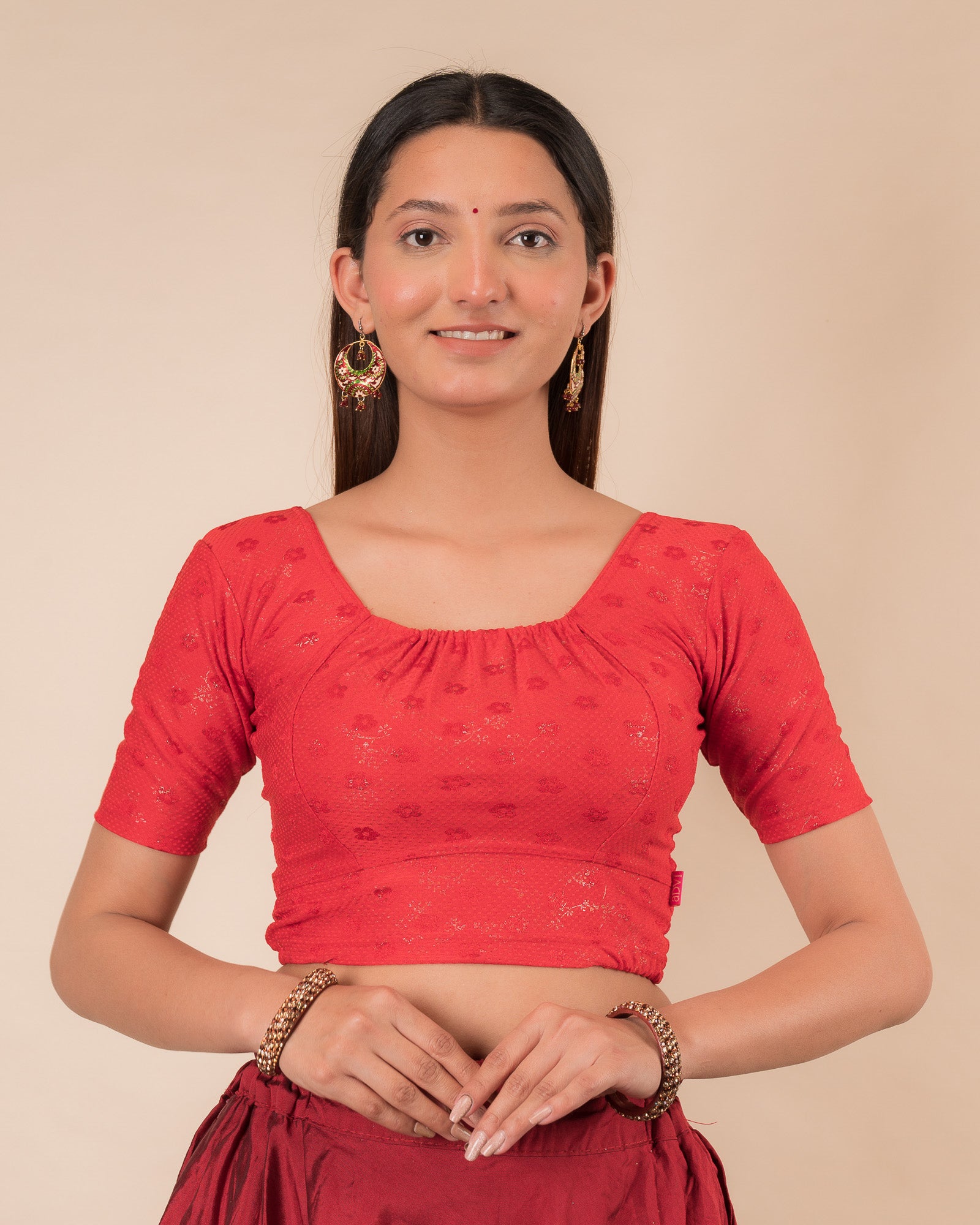 Model wearing a metallic zig-zag striped stretchable choli-style blouse with elbow sleeves and round neckline
