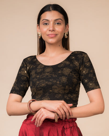 Model wearing a maroon foil and stone-embellished stretchable blouse with elbow sleeves and round neckline