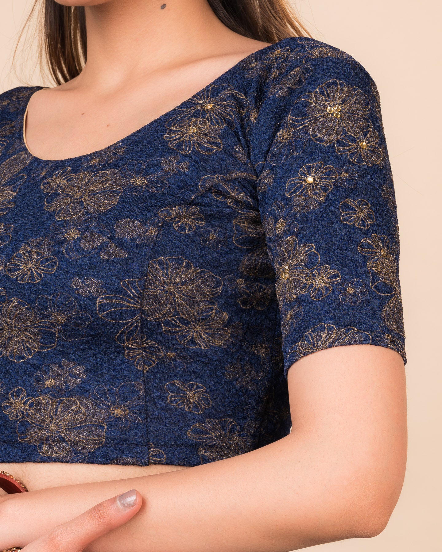 Close-up detailing the floral foil texture and stone work on jacquard fabric