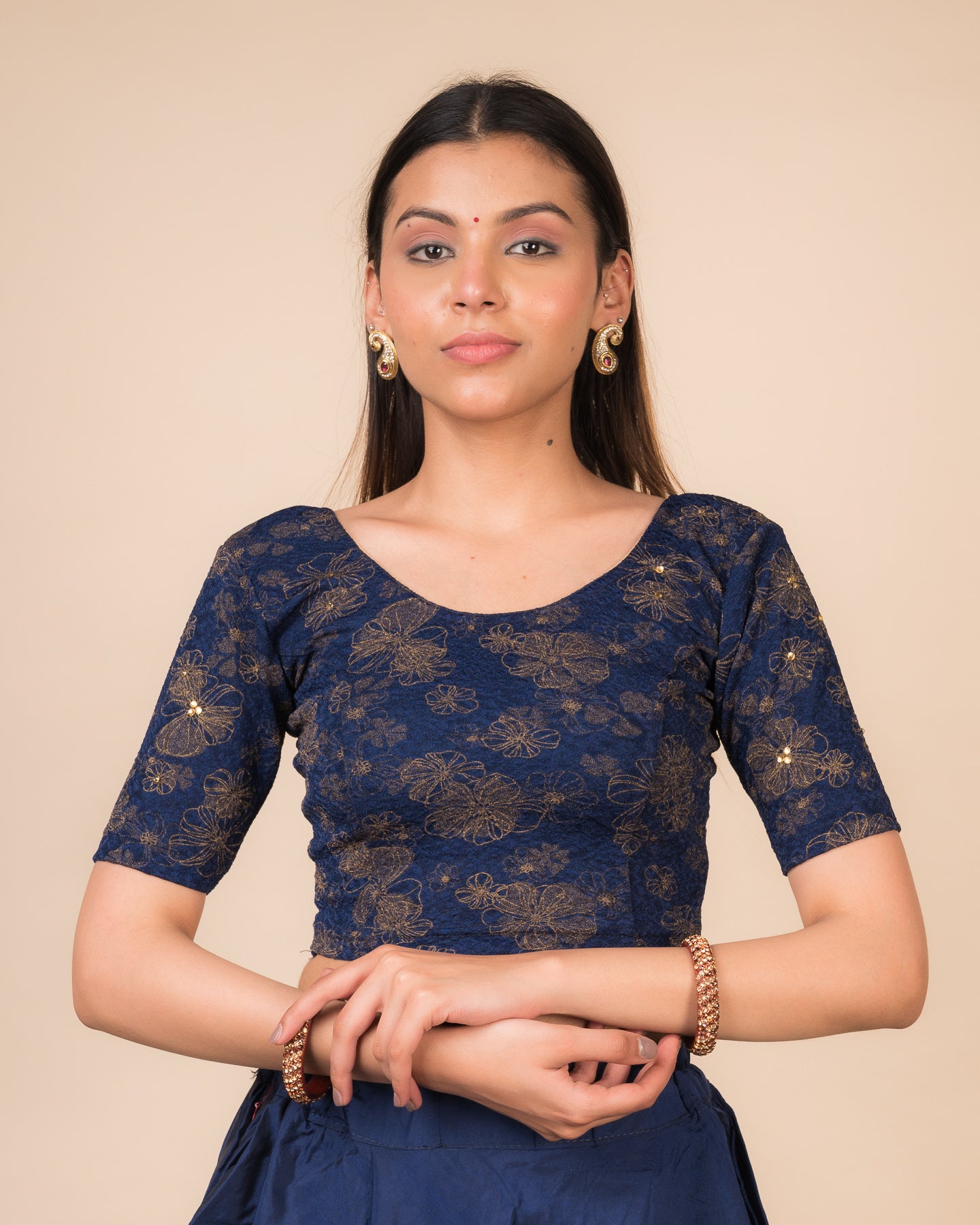 Model wearing a maroon foil and stone-embellished stretchable blouse with elbow sleeves and round neckline