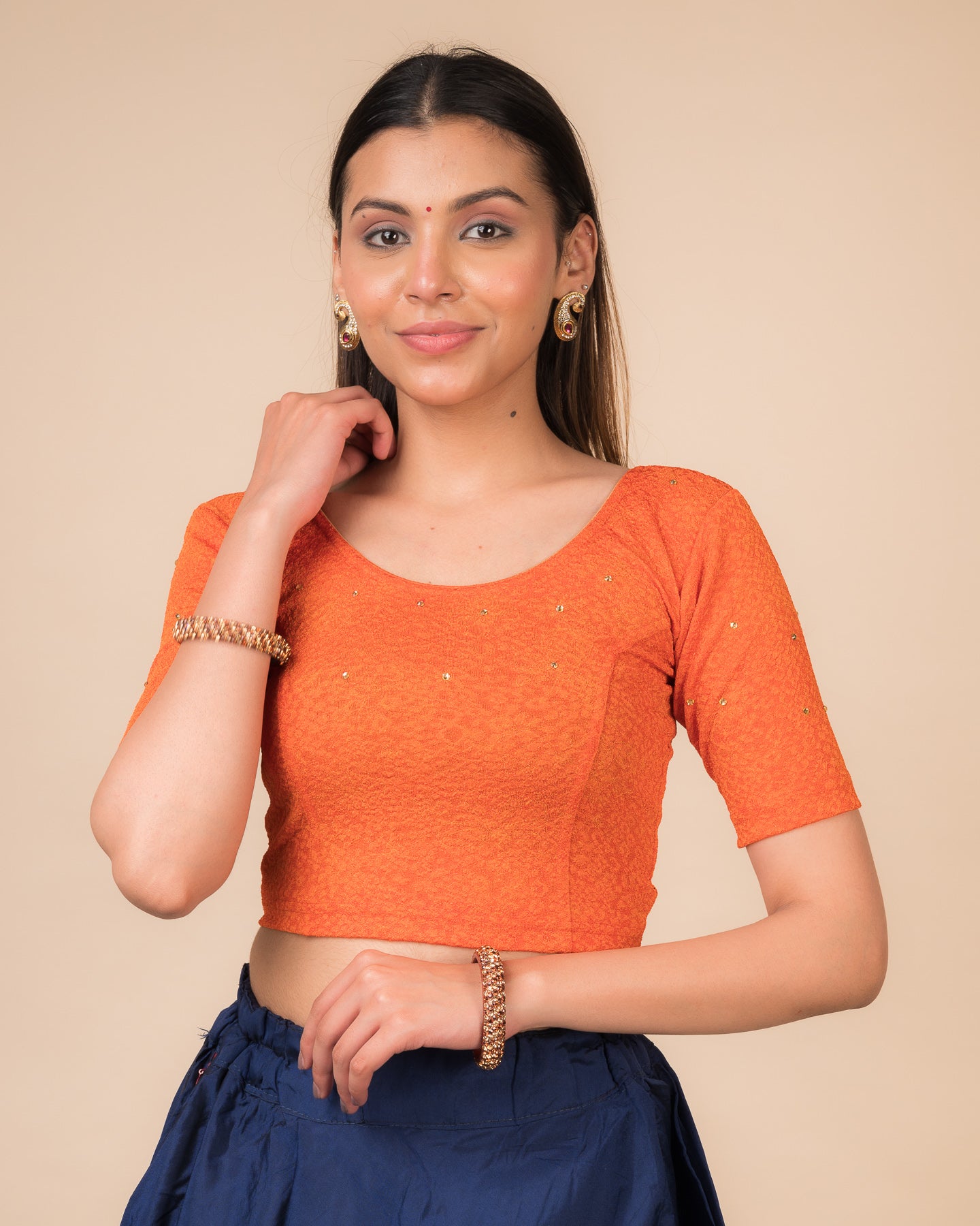  Model wearing a maroon foil and stone-embellished stretchable blouse with elbow sleeves and round neckline