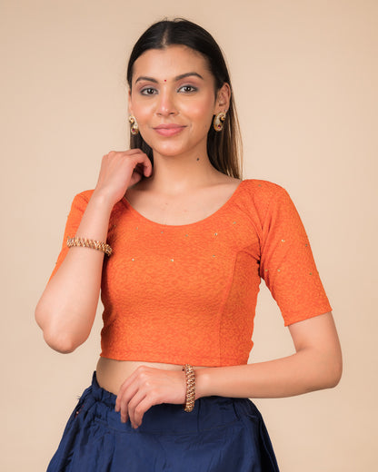  Model wearing a maroon foil and stone-embellished stretchable blouse with elbow sleeves and round neckline