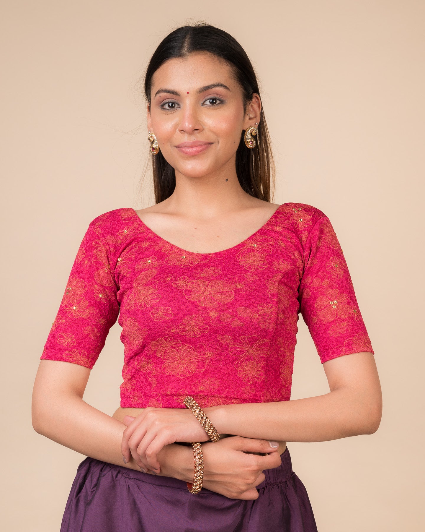  Model wearing a maroon foil and stone-embellished stretchable blouse with elbow sleeves and round neckline