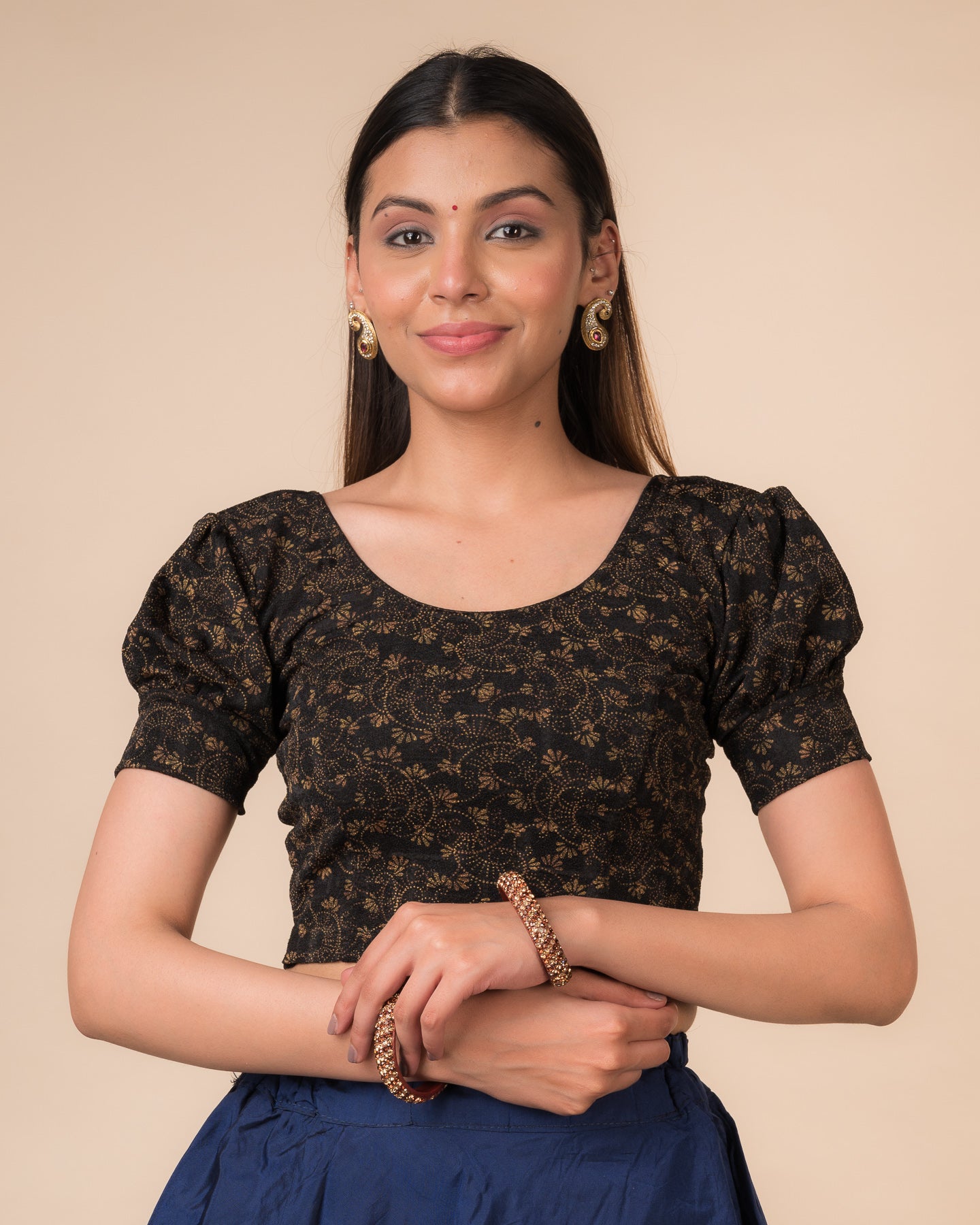 Model wearing a navy stretchable blouse with elbow sleeves, metallic print, and round neckline