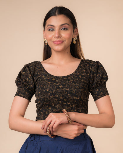 Model wearing a navy stretchable blouse with elbow sleeves, metallic print, and round neckline