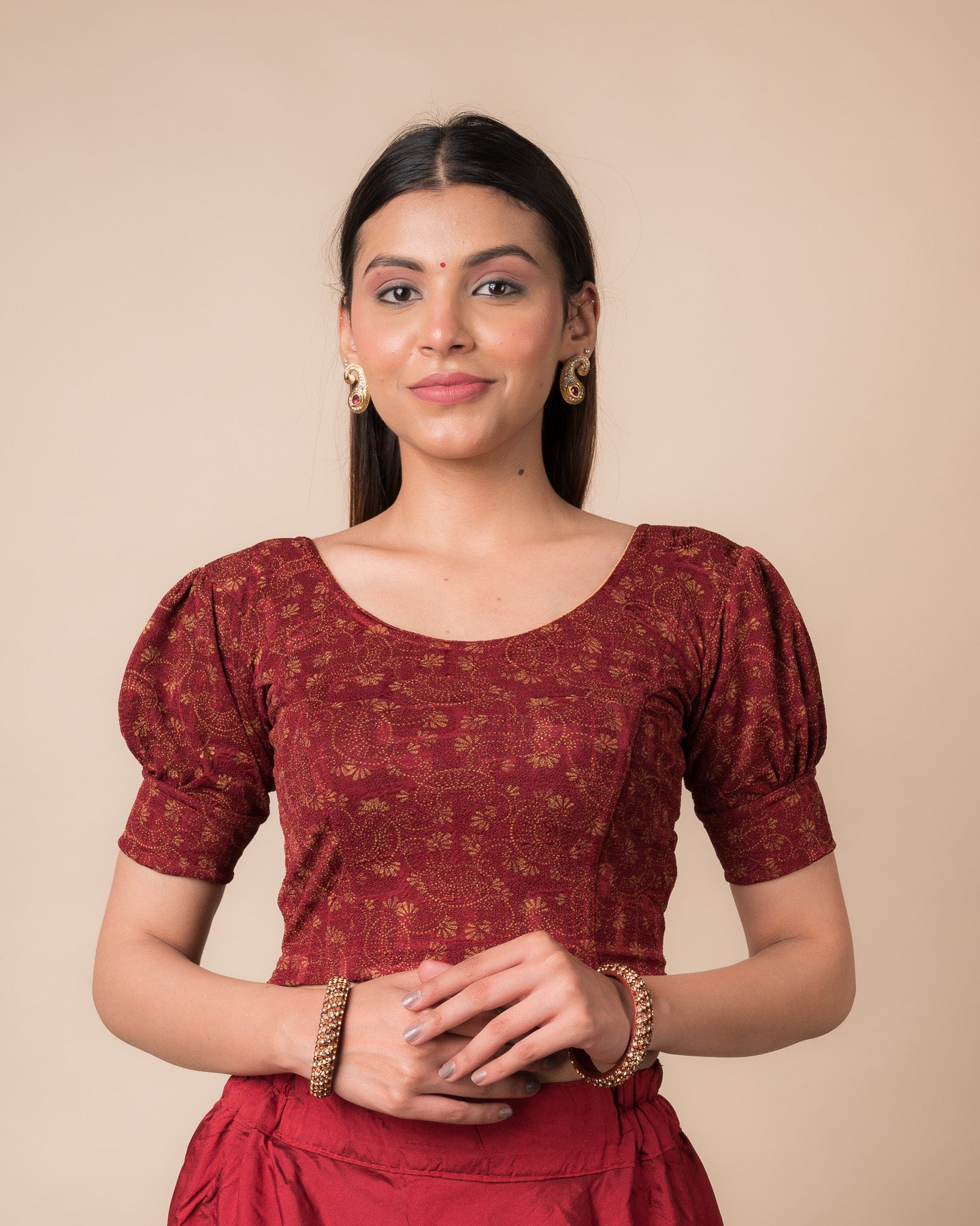 Model wearing a navy stretchable blouse with elbow sleeves, metallic print, and round neckline