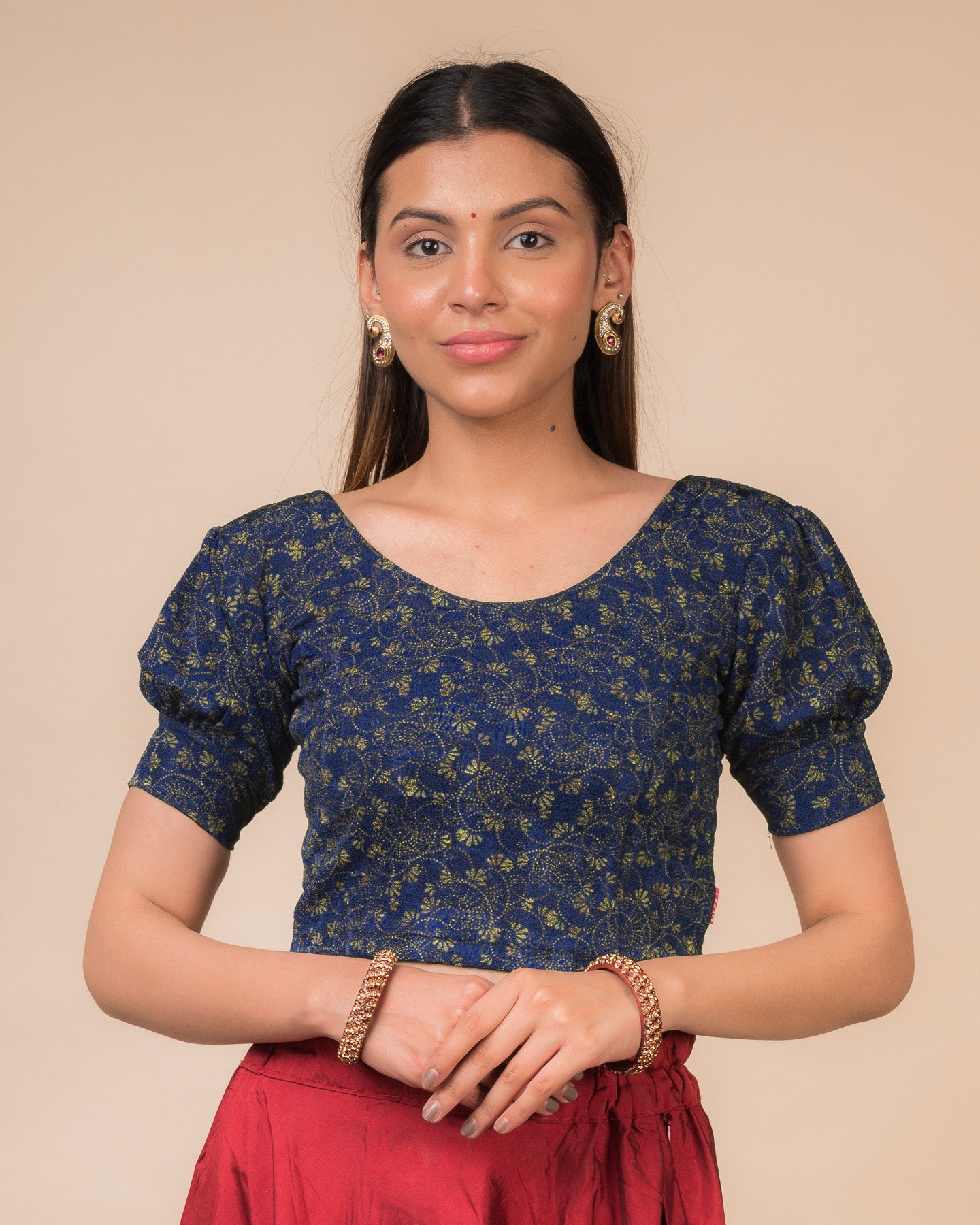 Model wearing a navy stretchable blouse with elbow sleeves, metallic print, and round neckline