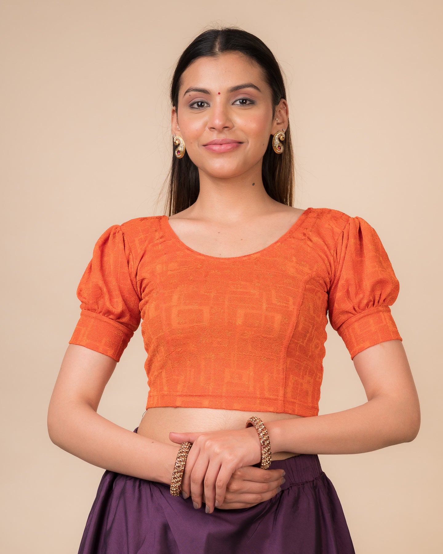Model wearing a navy stretchable blouse with elbow sleeves, metallic print, and round neckline