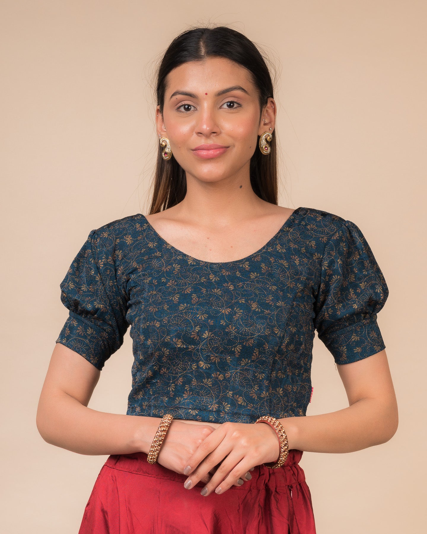 Model wearing a navy stretchable blouse with elbow sleeves, metallic print, and round neckline