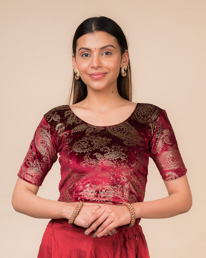 Model wearing a maroon velvet stretchable blouse with gold paisley prints, elbow sleeves, and round neckline.